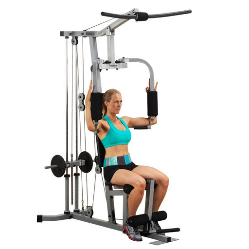 White female athlete in a teal top performing pec deck exercise on Powerline Home Gym PHG1000X.