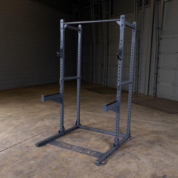 Powerline Half Rack PPR500, four-post setup with pin and pipe safeties for secure and safe weightlifting exercises in a home gym plus spotter arms in warehouse